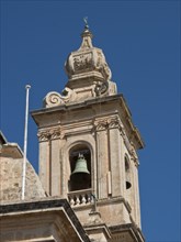 Detailed view of a baroque bell tower with decoration and blue sky in the background, Historic