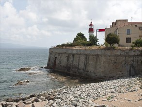Coastline with a lighthouse and old buildings on a rocky coast, Corsica, ajaccio, France, Europe