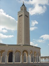 High minaret of a mosque in front of a clear blue sky, Tunis in Africa with ruins from Roman times,