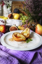 A rustic still life of fruits including pears, figs, and grapes, accented with spices and a bouquet