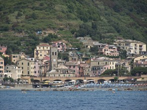 Picturesque coastal village on a mountainside with colourful houses and a central clock tower by