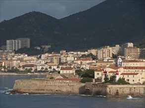 Coastal town with historic and modern buildings bordering the coastal defence heights, Corsica,