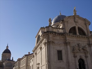 Historic building with dome and statues in front of a clear blue sky, the old town of Dubrovnik