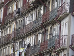 Facades of multi-storey buildings with classic balconies and metal railings, old houses in the