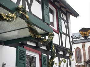 Half-timbered house with green shutters and Christmas garland, kandel, germany