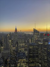 Cityscape at sunset with various skyscrapers and the empire state building in the background, the