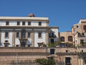 View of a multi-storey historic building with balconies under a clear blue sky, palermo in sicily