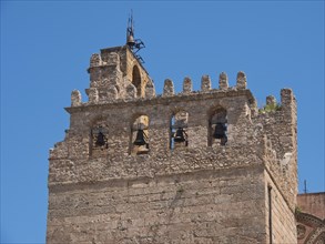 An old stone tower with bells against a clear blue sky, palermo in sicily with an impressive