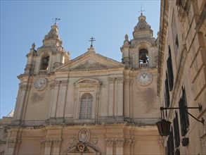 Front view of a magnificent historic church with two bell towers, the town of mdina on the island