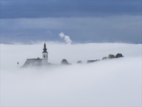 Church tower rises out of the morning mist, Frauenberg pilgrimage church, near Leibnitz, Styria,