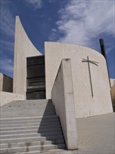 Modern church with cross and angular architecture under a blue sky, Barcelona, Spain, Europe