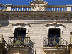 Close-up of a classic stone facade with decorative balustrade and ornate windows, palma de Majorca