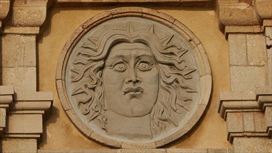 Sun god Helios, close-up of a stone sun face as a relief on an old building, Old Town of Rhodes,
