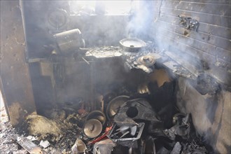 A burnt and smoky kitchen filled with debris showing severe fire damage, Encounter, Pulwama, Jammu