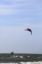 A kite surfer enjoys the waves on a glorious day along the Dutch coast. Castricum, Netherlands