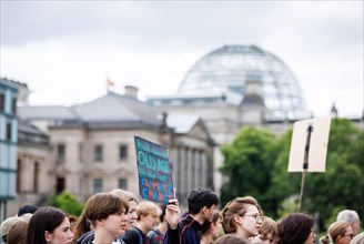 Demonstrators with signs at Fridays for Future in front of the Reichstag building, taken during the
