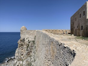 Left round watchtower and fortress wall on Mediterranean coast right part of house of councillors
