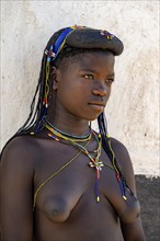 Hakaona woman with traditional kapapo hairstyle, portrait, and colourful necklaces, in the morning