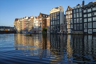 A view of Amsterdam houses by the canal in the Damark area in beautiful evening light in the month