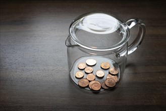 Symbol of poverty, A glass container with a few cent pieces, little money