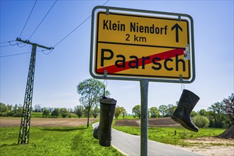 Boots on town sign, farmers' protest, Paarsch, Rome, Mecklenburg-Western Pomerania, Germany, Europe