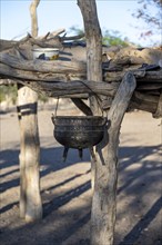 Kettle, cooking pot hanging on a wooden rack, Hakaone village, near Opuwo, Kunene, Namibia, Africa
