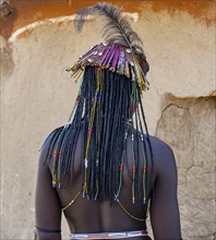 Hakaona woman with traditional kapapo hairstyle and hair ornaments with ostrich feathers, and