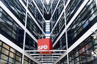 Modern glass facades of a tall office building with SPD logo in the entrance area,