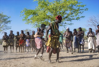 Group of Hakaona woman and men, dancing and clapping, Angolan tribe of the Hakaona, near Opuwo,