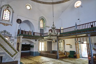Retzep Pasha Mosque, interior of a mosque with prayer rugs, chandeliers, windows and historical