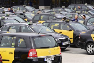 Barcelona, Catalonia, Spain, Europe, Many yellow-black taxis parked in a car park, people moving