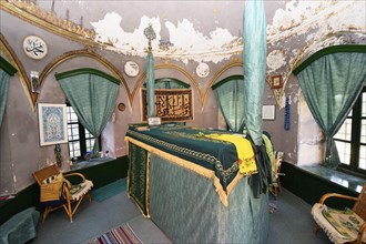Mausoleum, prayer room with cloth-covered tomb, religious symbols and furnished with chairs and