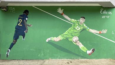 Street art mural shows the Argentinian national goalkeeper Emiliano Martinez in a decisive scene of