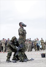 German soldiers from an NBC defence unit in protective clothing practise decontamination during the