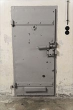 Solid grey metal cell door, firmly locked. Cool industrial aesthetics, Berlin-Hohenschoenhausen