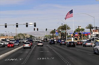 Las Vegas, Nevada, USA, North America, A busy street with cars, an American flag and shops in the