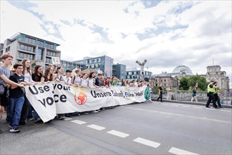 Demonstrators with signs at Fridays for Future in front of the Reichstag building, taken during the