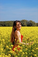 Woman stands in a rape field and laughs at you