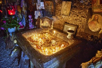 Rock Chapel, Archangel Michael Panormitits, Illuminated altar with burning candles in a cave,
