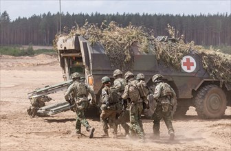 German and Dutch soldiers evacuate a simulated injured comrade as part of the NATO large-scale