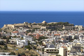 View from elevated position over rooftops of city of Rethymno on fortress walls and ruins of