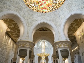A majestic interior with ornate arches and golden decorations, illuminated by a magnificent