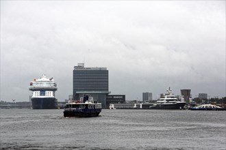 A view of vessels in the port of Amsterdam with a ferry in the foreground. Amsterdam, Netherlands