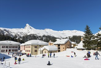 Beautiful Swiss Ski Slope with Houses on the Mountain with Snow in Winter in a Sunny Day with Blue