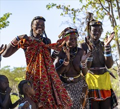 Hakaona woman with traditional kapapo hairstyle, clapping and laughing, Angolan tribe of the