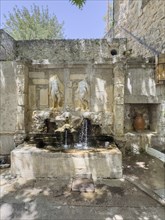 Venetian fountain depicting weathered relief of Adam and Eve in front of the Tor tor of Eastern
