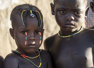 Two Hakaona children with traditional hairstyle, portrait, in the morning light, Angolan tribe of