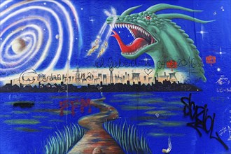 Mural shows a dragon above a skyline at night, surrounded by a lake, stars and spiral pattern,