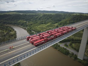 Trucks with a total weight of 960 tonnes stand on the Moselle valley bridge in Winningen during a