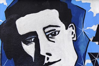 Cubist black and white portrait of a face with blue background on a wall, mural, East Side Gallery,